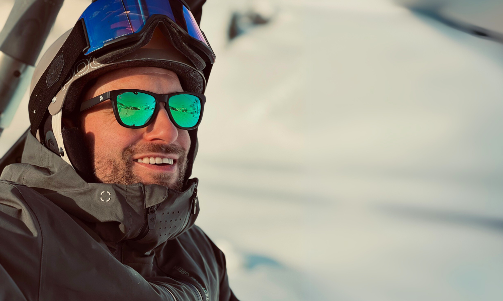 Jongen in een ski lift met een ski zonnebril met groene spiegelglazen